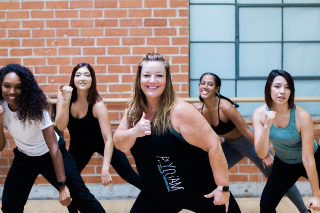 Dance fitness class smiling while listening to music